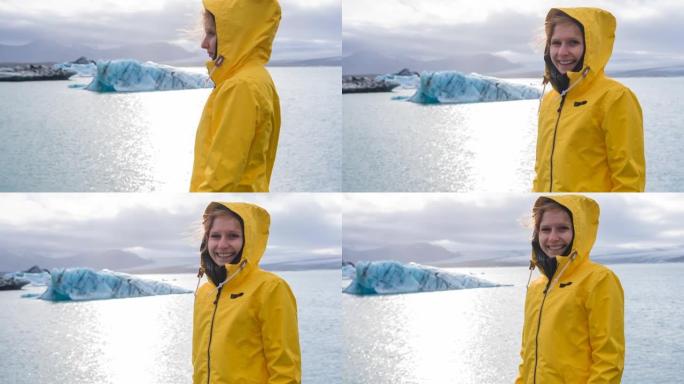 穿着黄色雨衣的女人看着冰山