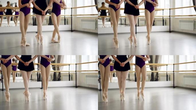 穿着芭蕾舞鞋的女性双腿低射学生和老师tip着脚尖在舞厅的地板上跳舞。编舞、古典芭蕾、艺术和儿童概念。