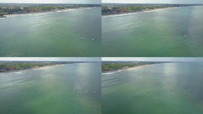 空中: 成群的冲浪者排队等候在巴厘岛冲浪点赶上海浪