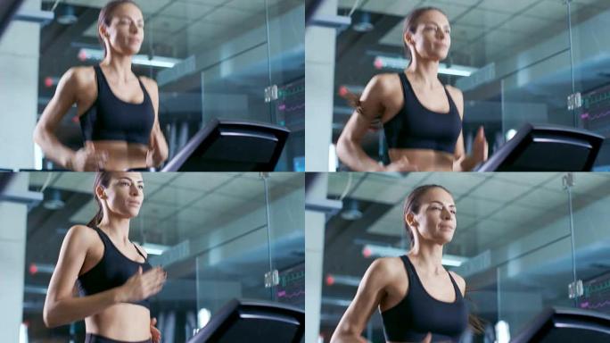 穿着运动胸罩的漂亮女人运动员，在跑步机上行走，训练锻炼。在背景现代健身房/健身俱乐部。