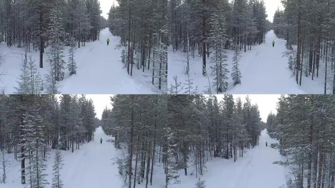 空中特写: 无法辨认的女人在白雪皑皑的冬季森林中行走在冰冷的道路上
