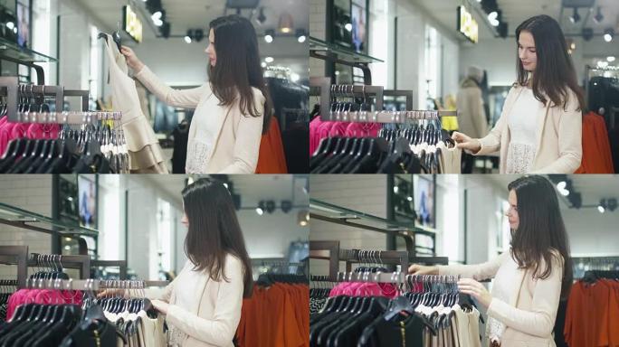 年轻的黑发女孩正在百货商店挑选衣服。