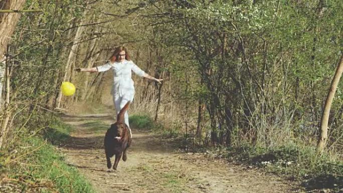 SLO MO女人和她的狗在森林里奔跑