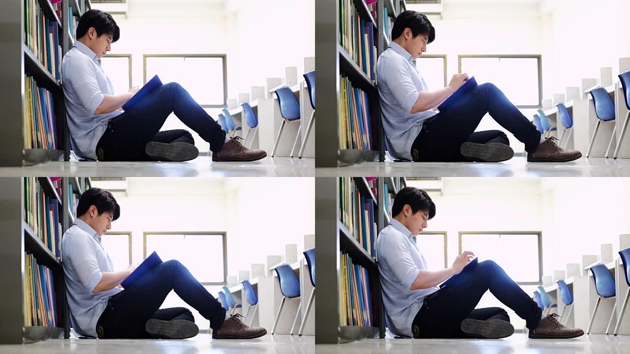 亚洲男大学生在图书馆阅读地板上进行学习研究