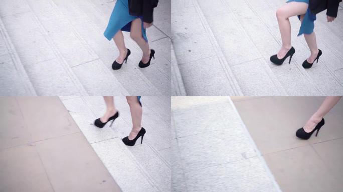 商业女人的腿在城市的楼梯上踩着。