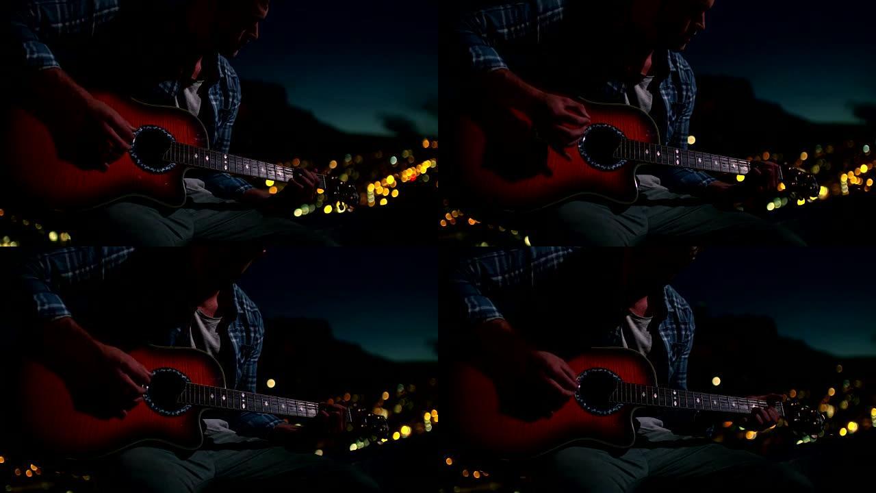 年轻人晚上坐在屋顶上弹吉他