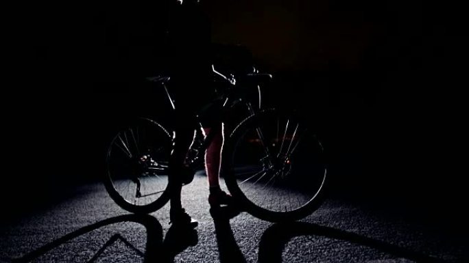 骑自行车的人摆姿势的低角度慢动作剪影