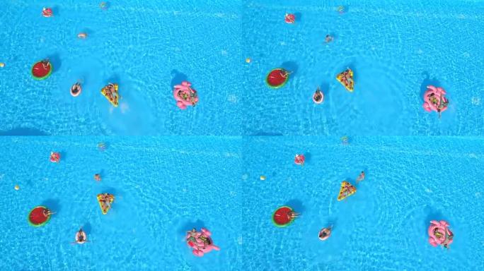 天线: 快乐的人们在泳池水中五颜六色的漂浮物上享受暑假