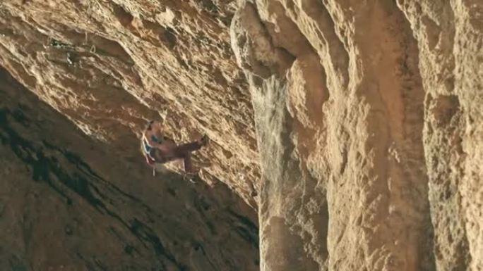 年轻的女攀岩者用粉笔蘸手，爬上比利牛斯山脉的一个艰难洞穴