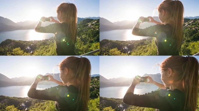 女人拍摄湖泊和湖边村的全景