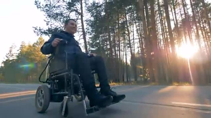 一个坐在轮椅上的人在森林路上兜风。
