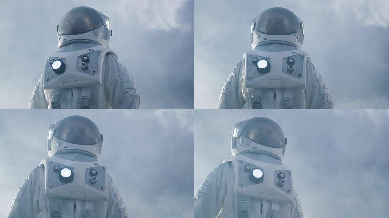 低角度拍摄的勇敢宇航员穿着宇航服环顾外星球。蓝色和寒冷的星球。先进技术，太空旅行，殖民概念。