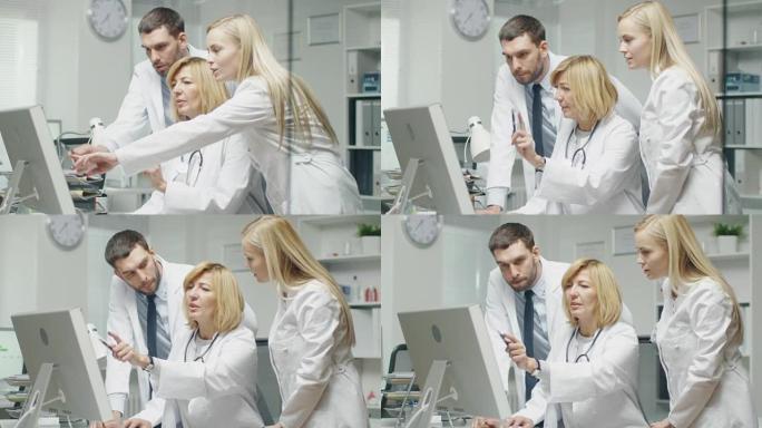 医务人员在使用个人计算机时讨论与工作相关的问题。他们指向屏幕并交谈。