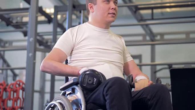 一名残疾人坐在轮椅上，坐着哑铃，移动肩膀，说话