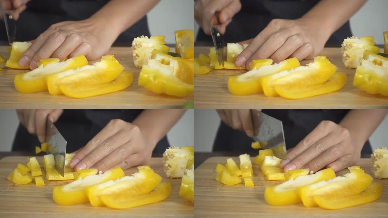 慢动作-女人在厨房的切菜板上制作健康食品和切碎甜椒的特写镜头。