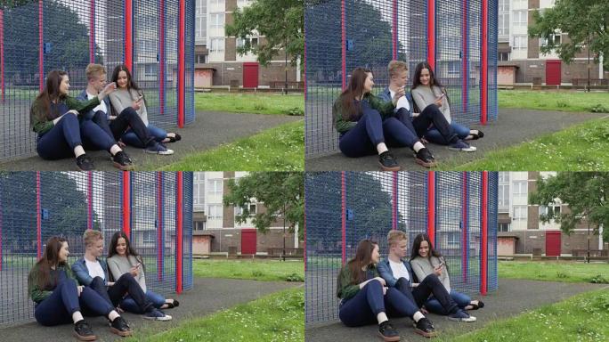 三个青少年在手机上在公园闲逛