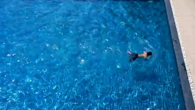 男子在游泳池游泳蛙泳