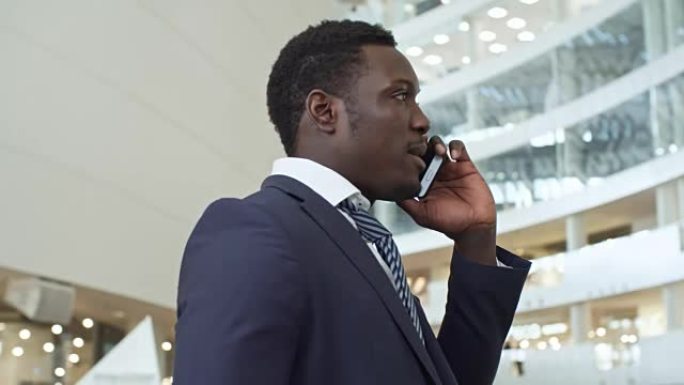 非洲企业家在大厅里用手机讲话