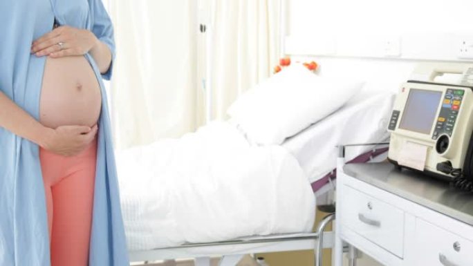 孕妇站在医院的长袍