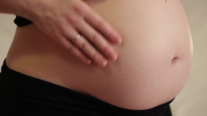孕妇抚摸她的腹部，倾斜拍摄