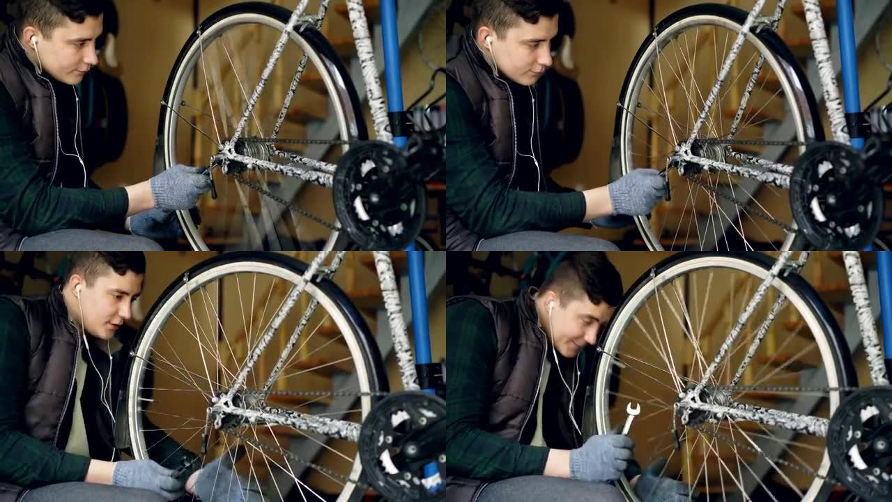 年轻的自行车维修大师正在用扳手和旋转轮调节轮机构，以检查工作质量。循环维护和工作人员概念。