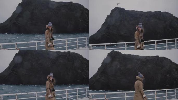 年轻漂亮的女人带着相机站在船上，环顾四周。快速摩托艇上的游客