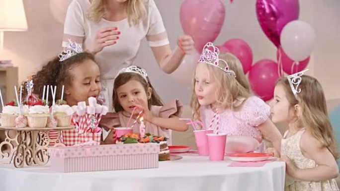 小女孩在生日蛋糕上吹蜡烛