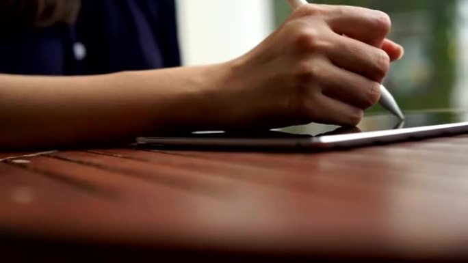 女人在平板电脑上手写商业计划书