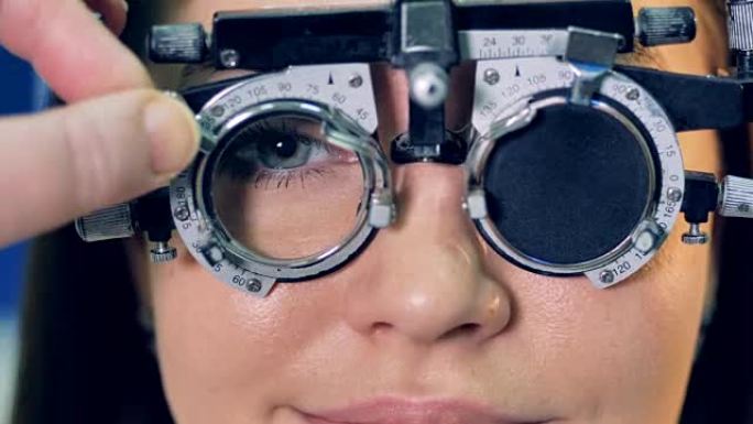 一位医生在妇女试验镜架内更换镜片。