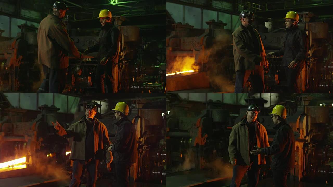 工程师和工人在铸造厂交谈。恶劣的工业环境。