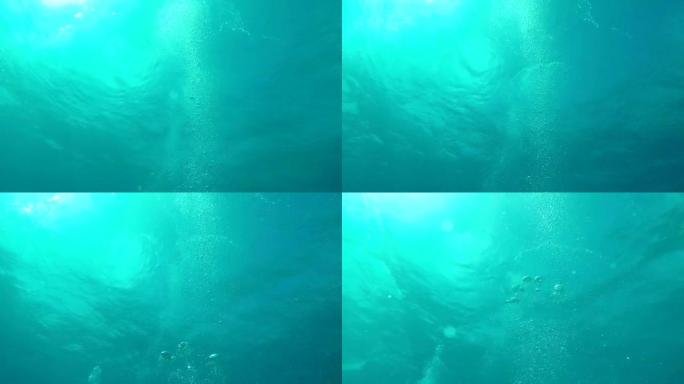 水下: 曼尼大气泡上升到荡漾的海面