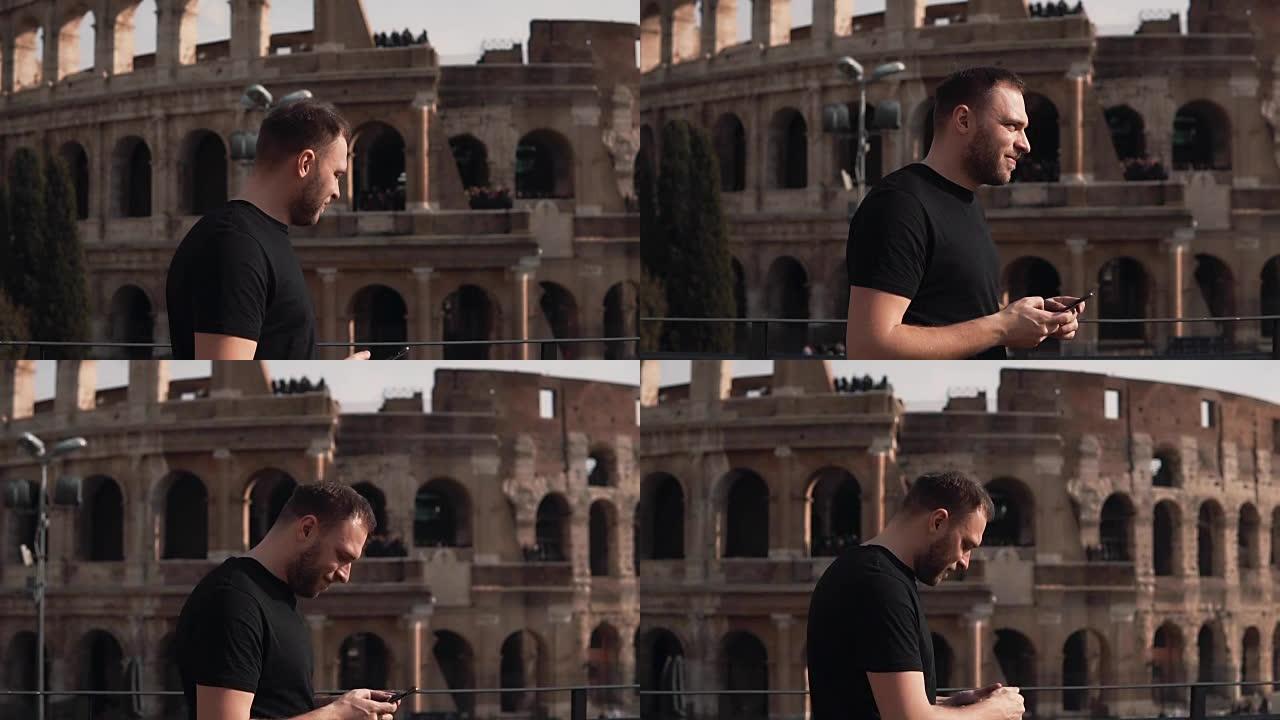 英俊的男性，在意大利罗马的罗马斗兽场散步，带着智能手机，探索这个国家。慢动作