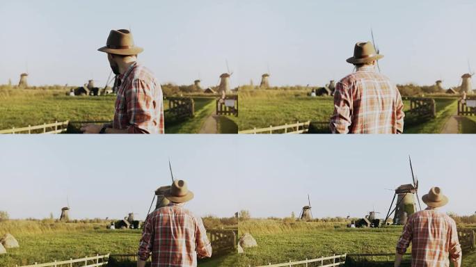4k成功欧洲农民男性肖像。穿着衬衫和帽子的男人，带着智能手机和智能手表走向磨坊