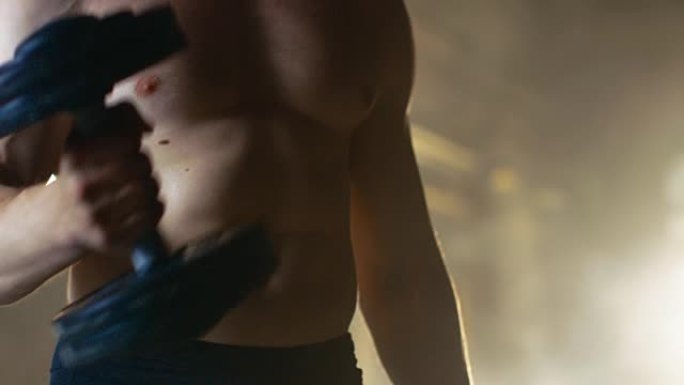 作为健美健身房训练的一部分，一个肌肉赤裸的男人的躯干特写镜头通过哑铃锻炼二头肌卷曲。