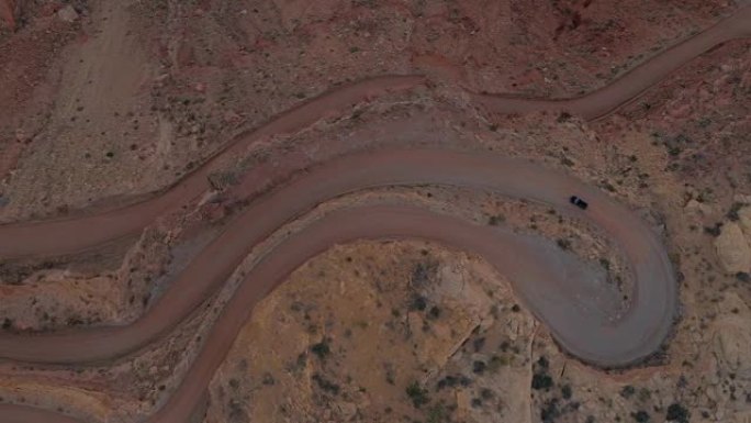 空中自上而下: 黑色SUV吉普车在梅萨沙漠危险的发夹路上行驶