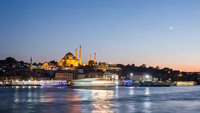 伊斯坦布尔城市景观的全景，苏莱曼清真寺和游船在夜间漂浮在博斯普鲁斯海峡
