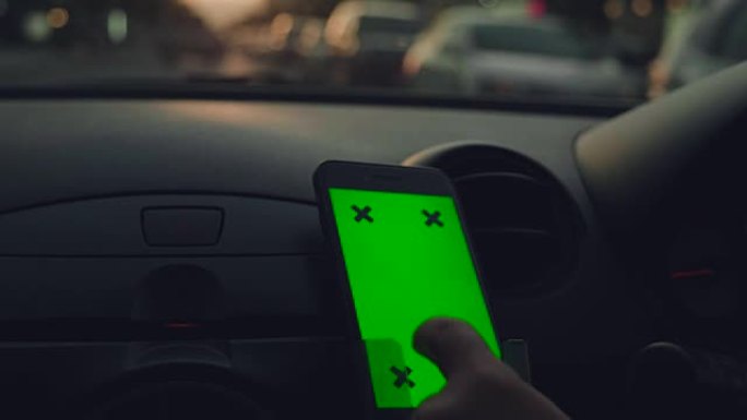 亚洲女性在汽车上使用智能手机的特写镜头，绿屏