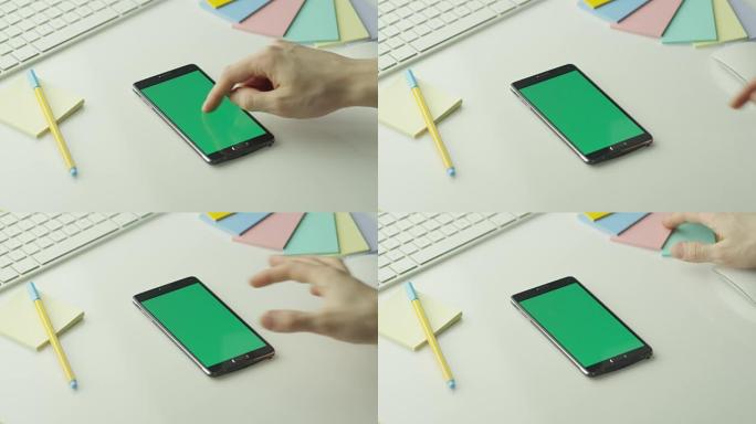 设计师正在纵向模式下使用带有绿屏的安卓手机。