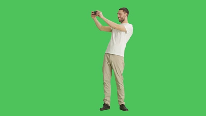 一个英俊的时尚男人在绿屏背景上自拍的长镜头。
