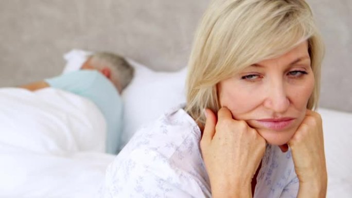 丈夫睡觉时不快乐的女人在思考