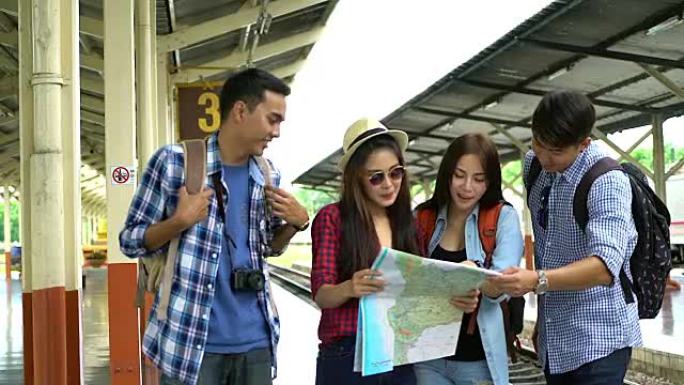 一群年轻的旅行者在火车站寻找地图并讨论他们的旅行。