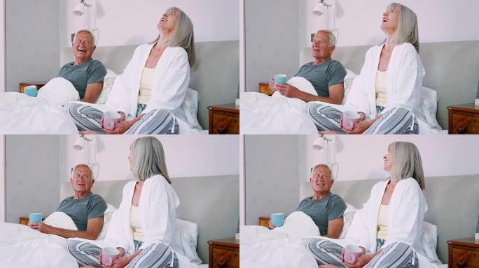 退休夫妇穿着睡衣坐在床上喝茶