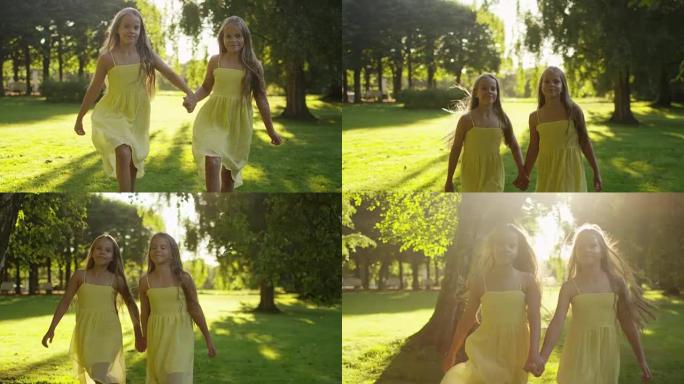 两个快乐的女孩在公园的阳光下奔跑