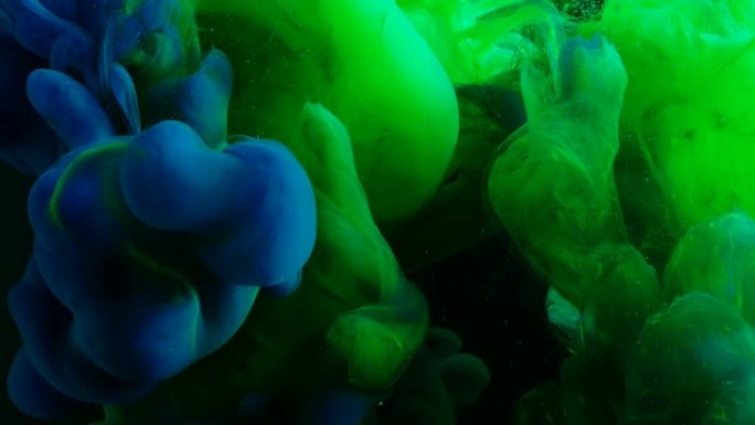 绿色和蓝色霓虹灯涂料混合在黑暗的空间。创造各种艺术造型。