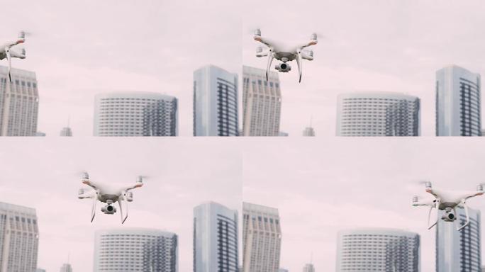 四轴飞行器无人机，云台上的摄像头在城市的天空中飞行，以慢动作拍摄