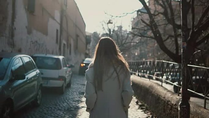 独自一人走在市中心的长发年轻女子的后景。女性去路边做梦
