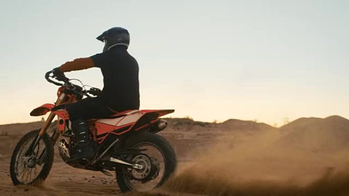 职业摩托车越野赛车手在越野沙道上驾驶他的摩托车。