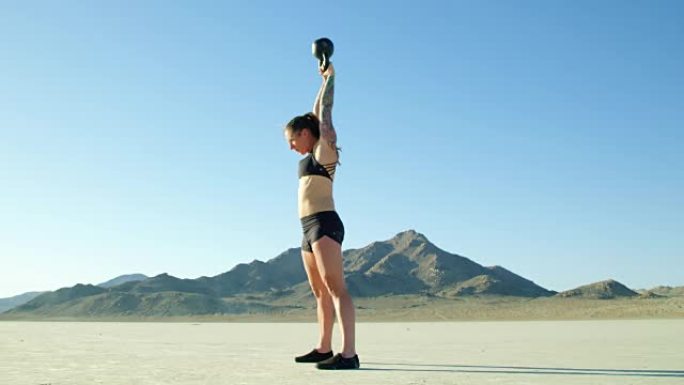 慢动作运动女做水壶铃摇摆沙漠举重锻炼