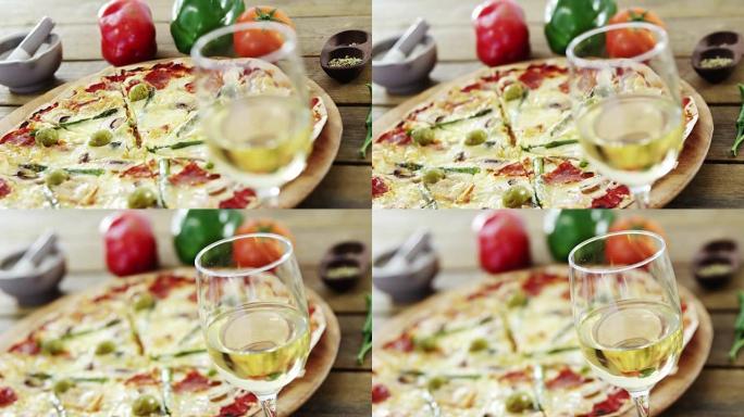 美味的披萨配一杯葡萄酒、蔬菜和香料