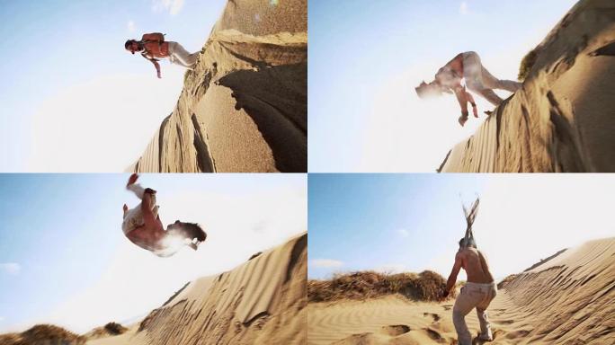 年轻的运动员在沙漠沙丘上进行后空翻跳跃